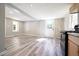 Open-concept kitchen area with wood-look flooring, stainless appliances, and natural light from the window and door at 6886 Upshaw Mill Rd, Douglasville, GA 30134