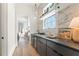 Butler's pantry with marble backsplash, sleek cabinetry, beverage fridge, and modern lighting at 245 Roycroft Ln, Fayetteville, GA 30214