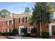 Inviting brick townhome with a blue door, manicured bushes, black shutters and a brick chimney at 4620 Wieuca Ne Rd # 32, Atlanta, GA 30342