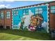 Brick building exterior features a mural of a young girl holding an airplane with empowering phrases at 941 Willingham Dr # 5, Hapeville, GA 30354