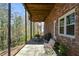 A brick back porch that has a metal table and chairs, as well as a wooded view at 2112 Starfire Ne Dr, Atlanta, GA 30345