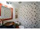 Charming powder room featuring bird-themed wallpaper, a copper sink, and a decorative mirror at 2112 Starfire Ne Dr, Atlanta, GA 30345