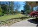 Beautiful landscaped yard with a stone retaining wall, red maple tree, and brick patio at 2112 Starfire Ne Dr, Atlanta, GA 30345