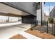 Long concrete driveway leading to covered parking area and garage with black fence and landscaping at 219 Howell Se Dr # A, Atlanta, GA 30316