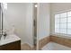 Bathroom featuring a vanity with solid surface countertop and tiled floor and tub surround at 310 Tuggle Court, Woodstock, GA 30188