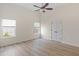 Bright bedroom featuring two windows with green views, a ceiling fan, and light wood flooring at 310 Tuggle Court, Woodstock, GA 30188
