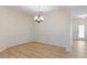 Elegant dining room featuring stylish wainscoting, a modern chandelier, and beautiful light wood flooring at 310 Tuggle Court, Woodstock, GA 30188