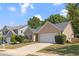 Traditional single-story home with a two-car garage, set in a neighborhood with mature trees and manicured lawns at 310 Tuggle Court, Woodstock, GA 30188