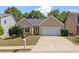 Charming single-story home featuring manicured lawn, neutral siding, and an attached two-car garage at 310 Tuggle Court, Woodstock, GA 30188