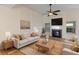 Bright living room with a fireplace, ceiling fan, and lots of natural light from large windows at 310 Tuggle Court, Woodstock, GA 30188