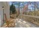 Relaxing back deck with a rocking chair overlooking a wooded backyard offers tranquility and outdoor living at 564 Grand Ashbury Ln, Sugar Hill, GA 30518