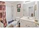 Well-maintained bathroom featuring a shower-tub combo, neutral tile, and vanity area at 564 Grand Ashbury Ln, Buford, GA 30518