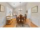 Bright dining room with wainscotting, wood floors, and decorative chandelier at 564 Grand Ashbury Ln, Sugar Hill, GA 30518