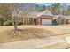 Classic brick home showcasing a manicured lawn, a two-car garage, and inviting front entrance with a charming porch at 564 Grand Ashbury Ln, Sugar Hill, GA 30518