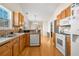 Bright kitchen boasts hardwood floors, light wood cabinetry, modern appliances, and a seamless transition to the dining area at 564 Grand Ashbury Ln, Sugar Hill, GA 30518