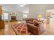 Inviting living room featuring hardwood floors, a brick fireplace, and comfortable leather furniture for a relaxing ambiance at 564 Grand Ashbury Ln, Sugar Hill, GA 30518