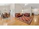 Open-concept living room with hardwood floors, a comfortable seating area, and an adjacent dining space for easy entertaining at 564 Grand Ashbury Ln, Sugar Hill, GA 30518