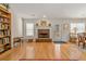 Cozy living room featuring hardwood floors, a brick fireplace, and an adjacent dining area bathed in natural light at 564 Grand Ashbury Ln, Sugar Hill, GA 30518