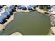 Aerial view featuring a picturesque pond, complemented by charming houses, enhancing the neighborhood's scenic beauty at 1295 Leisure Lake Dr, Lawrenceville, GA 30044