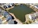 Aerial view showcasing a beautiful pond surrounded by well-maintained homes, enhancing the neighborhood's serene appeal at 1295 Leisure Lake Dr, Lawrenceville, GA 30044