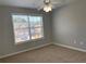 Bedroom with a ceiling fan and window showing a neighboring home with a garage at 1295 Leisure Lake Dr, Lawrenceville, GA 30044