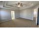 Large bedroom featuring plush carpet and tray ceiling with fan at 1295 Leisure Lake Dr, Lawrenceville, GA 30044