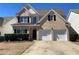 Traditional two-story home with brick accents, a well-kept lawn, and a spacious two-car garage at 1295 Leisure Lake Dr, Lawrenceville, GA 30044