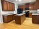 Spacious kitchen with hardwood floors, dark wood cabinets, and an island with granite countertop at 1295 Leisure Lake Dr, Lawrenceville, GA 30044