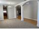 Open-concept living area with arched doorways and hardwood floors transitioning to carpet at 1295 Leisure Lake Dr, Lawrenceville, GA 30044