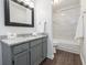 Modern bathroom with gray vanity, granite countertop, framed mirror, and a marble tiled shower at 1303 Highland Bluff Se Dr # 303, Atlanta, GA 30339