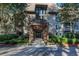 Charming building entrance with a wooden pergola and stone exterior surrounded by lush greenery at 1303 Highland Bluff Se Dr # 303, Atlanta, GA 30339