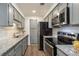 Well-equipped kitchen with stainless steel appliances, granite countertops, and gray cabinetry, ready for cooking at 1303 Highland Bluff Se Dr # 303, Atlanta, GA 30339