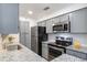 A full kitchen featuring stainless steel appliances, granite countertops, and modern, grey cabinets at 1303 Highland Bluff Se Dr # 303, Atlanta, GA 30339