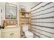 Neat bathroom with decorative shelving over toilet, a decorative shower curtain and neutral color palette at 30 Apache Ct, Locust Grove, GA 30248