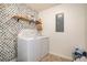 Laundry room with washer and dryer, wallpaper, and built in storage for laundry supplies at 30 Apache Ct, Locust Grove, GA 30248