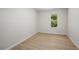 This is a small bedroom featuring light wood-look flooring and a window with green foliage outside at 5541 Downs Way, Lithonia, GA 30058