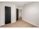 This bedroom features black interior doors, light wood-look floors, and a view to other rooms at 5541 Downs Way, Lithonia, GA 30058