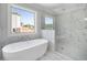 Elegant bathroom featuring a modern tub and a glass-enclosed shower with marble-style tile and a view at 3312 Steeple Chase Sw Way, Conyers, GA 30094