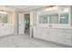 Bathroom featuring double vanity with marble countertops, white cabinets, and marble style floor tiles at 3312 Steeple Chase Sw Way, Conyers, GA 30094