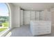 Spacious closet with island, built-in shelves and drawers with natural light from a large arched window at 3312 Steeple Chase Sw Way, Conyers, GA 30094