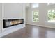 Modern living room with a sleek fireplace, hardwood floors, and multiple windows for lots of natural light at 3312 Steeple Chase Sw Way, Conyers, GA 30094