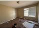 A simple bedroom with a window providing natural light, beige walls, and neutral-toned carpet at 430 N Oakland Cir, Mcdonough, GA 30253
