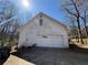 View of a two-car garage featuring white siding and mature trees surrounding the property at 430 N Oakland Cir, Mcdonough, GA 30253