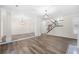 Open concept living room with light hardwood floors, staircase, columns, and modern light fixtures at 1920 Rosebriar Dr, Marietta, GA 30066