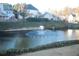 View of the fountain in the pond with homes in the background and green space in the foreground at 1920 Rosebriar Dr, Marietta, GA 30066