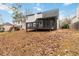 Exterior of a home featuring a screened in porch and deck and a large yard covered in fallen leaves at 3119 Blue Heron Pass, Powder Springs, GA 30127
