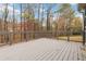 A spacious wood deck is surrounded by trees and features a gray railing with natural wood tones for a serene outdoor experience at 3119 Blue Heron Pass, Powder Springs, GA 30127