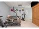 Home gym with carpet floor, armoire, elliptical, stationary bike and fitness equipment at 3718 Thunder Ne Way, Marietta, GA 30066