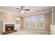 Cozy living room with a brick fireplace, built-in shelving, and large windows offering scenic views at 407 Trotters Run, Woodstock, GA 30188