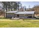 Beautiful backyard with a large deck, swing, and well-maintained lawn, surrounded by mature trees at 5320 Karr Rd, Cumming, GA 30040